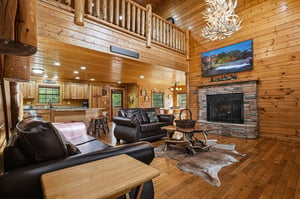 Unwind in your rustic cabins great room where leather seating surrounds a stone fireplace, while soaring log ceilings create mountain lodge charm.