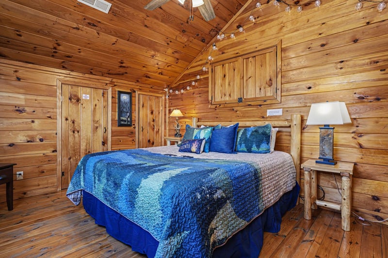 Snuggle into your rustic log cabin bedroom, where warm wood surrounds you and twinkling lights create magical ambiance for peaceful nights.