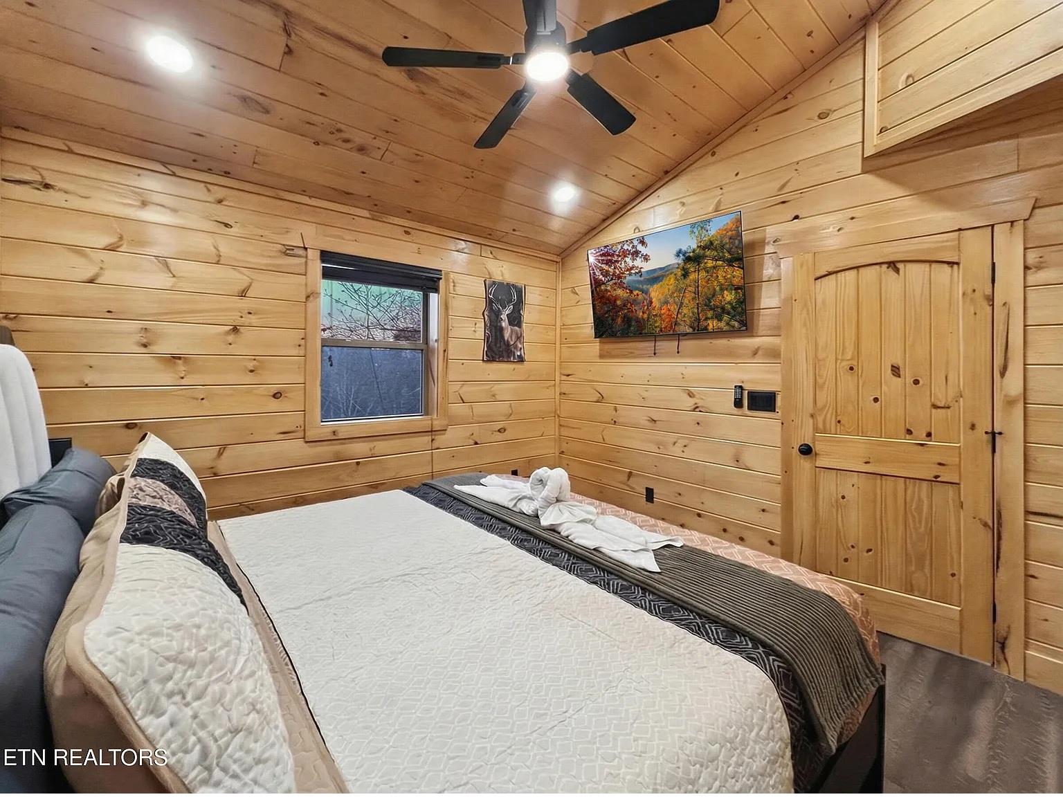 Drift off in your cozy cabin bedroom, where warm wood surrounds you and nature artwork sets a peaceful tone.