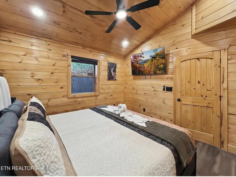 Drift off in your cozy cabin bedroom, where warm wood surrounds you and nature artwork sets a peaceful tone.