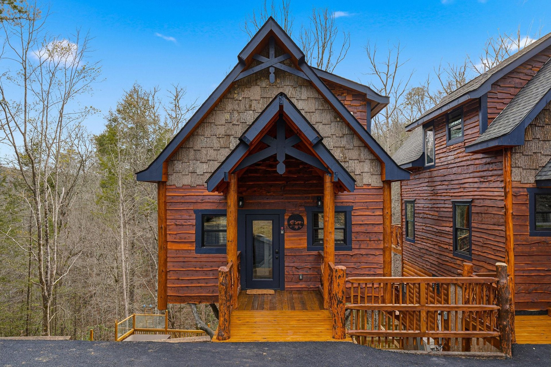 Charming mountain cabin with rustic wood siding and welcoming covered entrance surrounded by peaceful wooded setting.