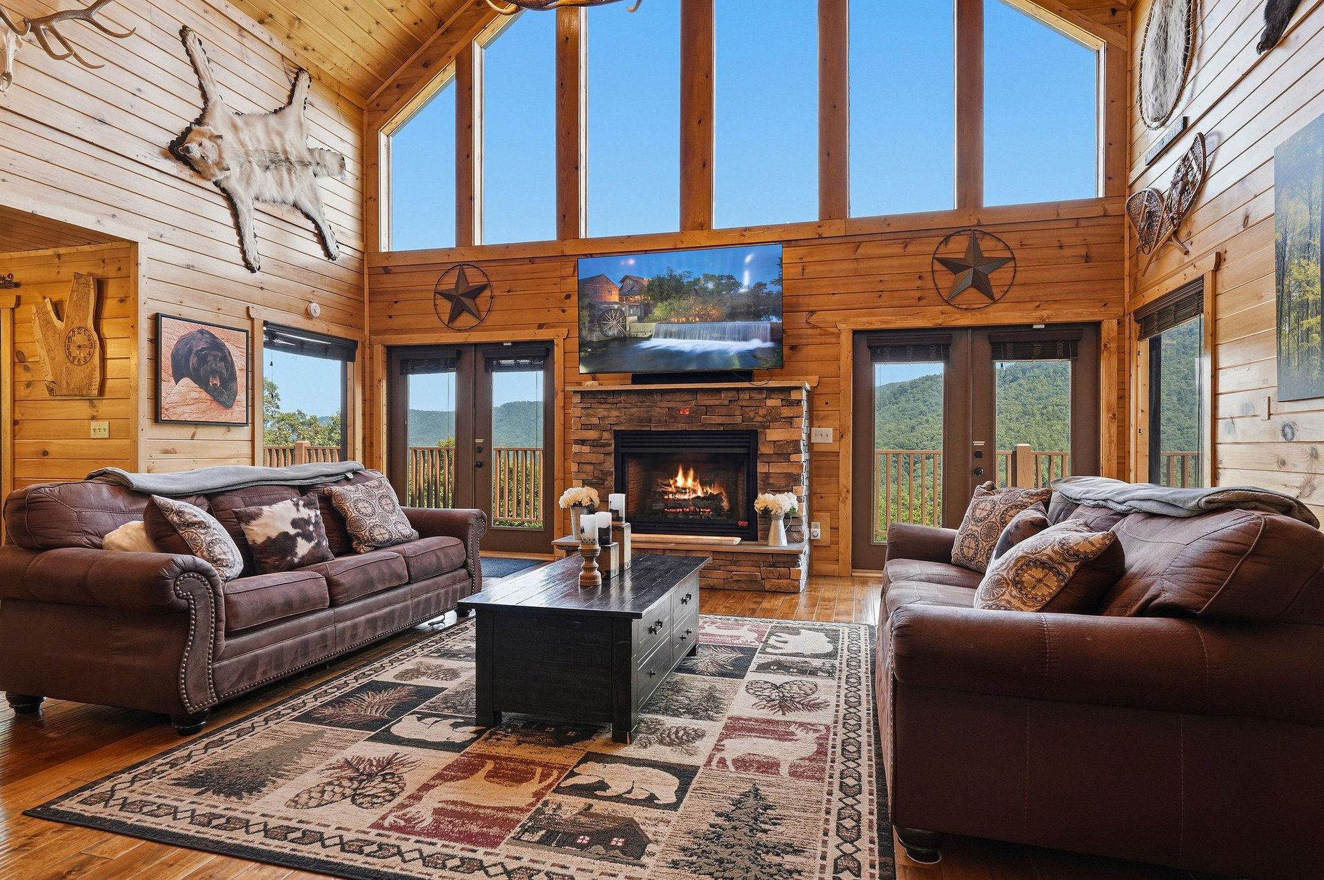 Sink into plush leather sofas by the stone fireplace, gazing through soaring windows at mountain peaks rolling into the distance—your perfect retreat awaits.