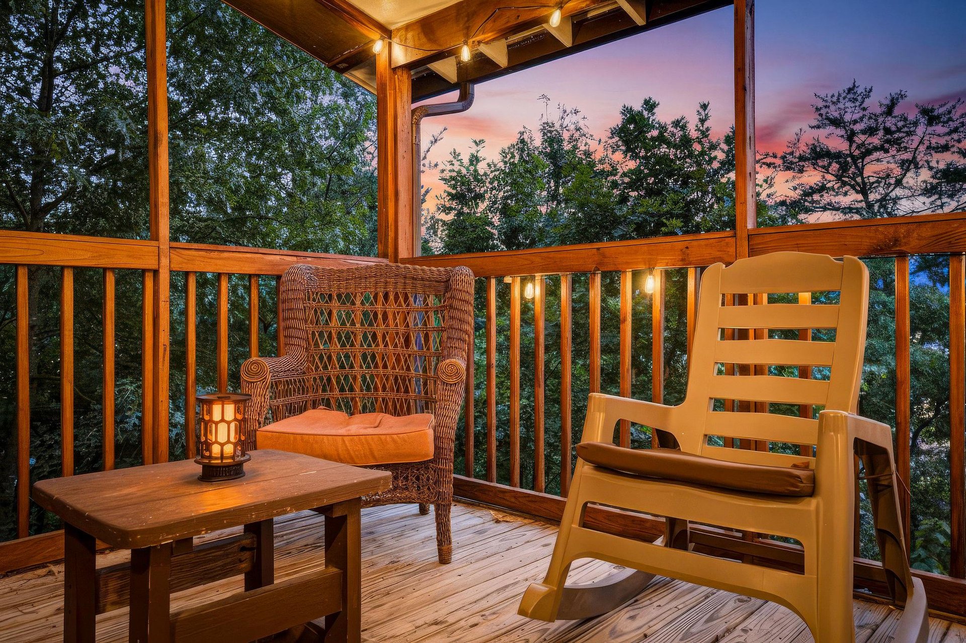 Unwind on your private covered deck with a rocking chair and cozy seating as golden hour paints the trees with warm light.