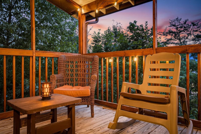 Unwind on your private covered deck with a rocking chair and cozy seating as golden hour paints the trees with warm light.