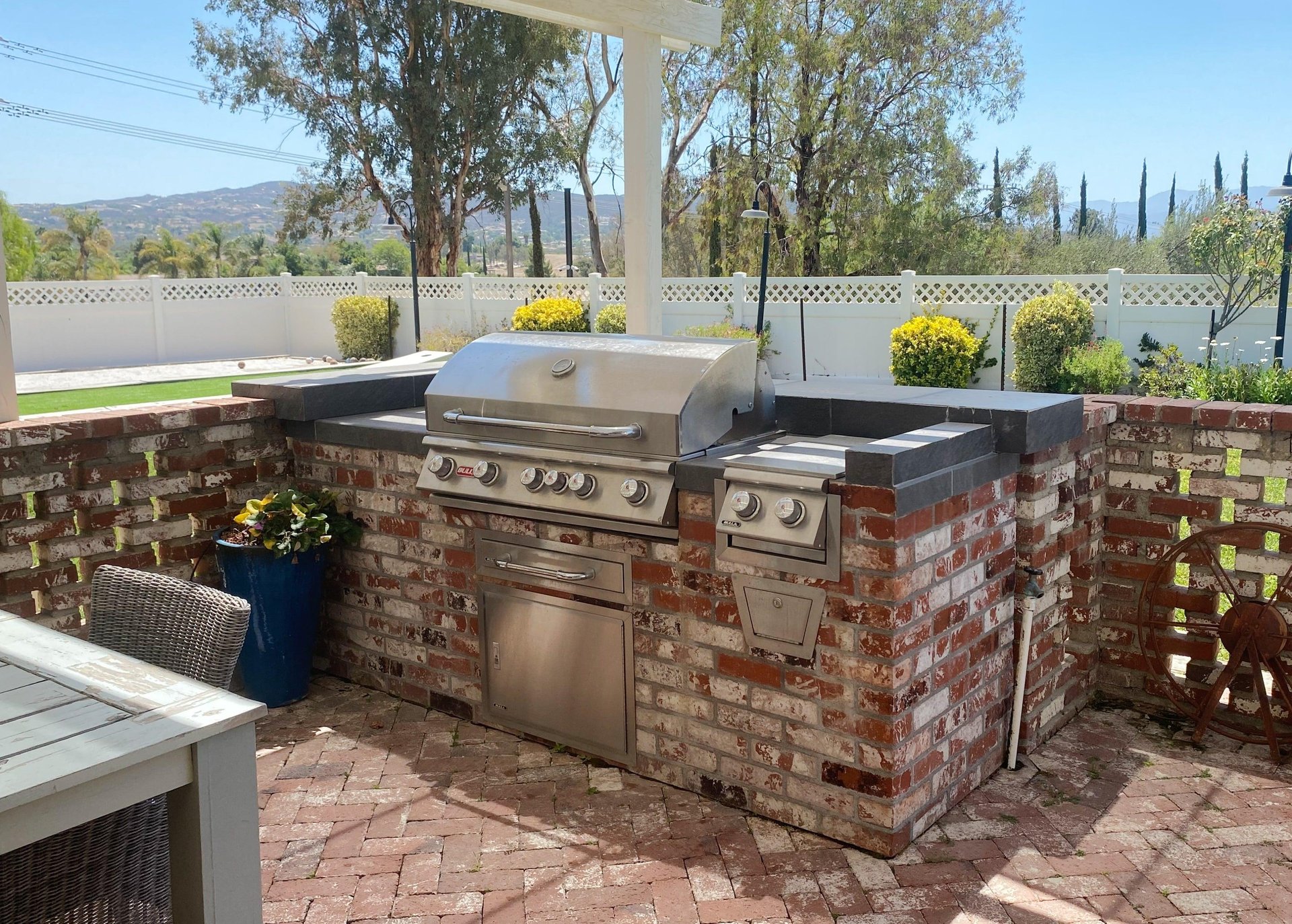 Follow the garden path to French doors and an inviting outdoor dining area with a BBQ grill.