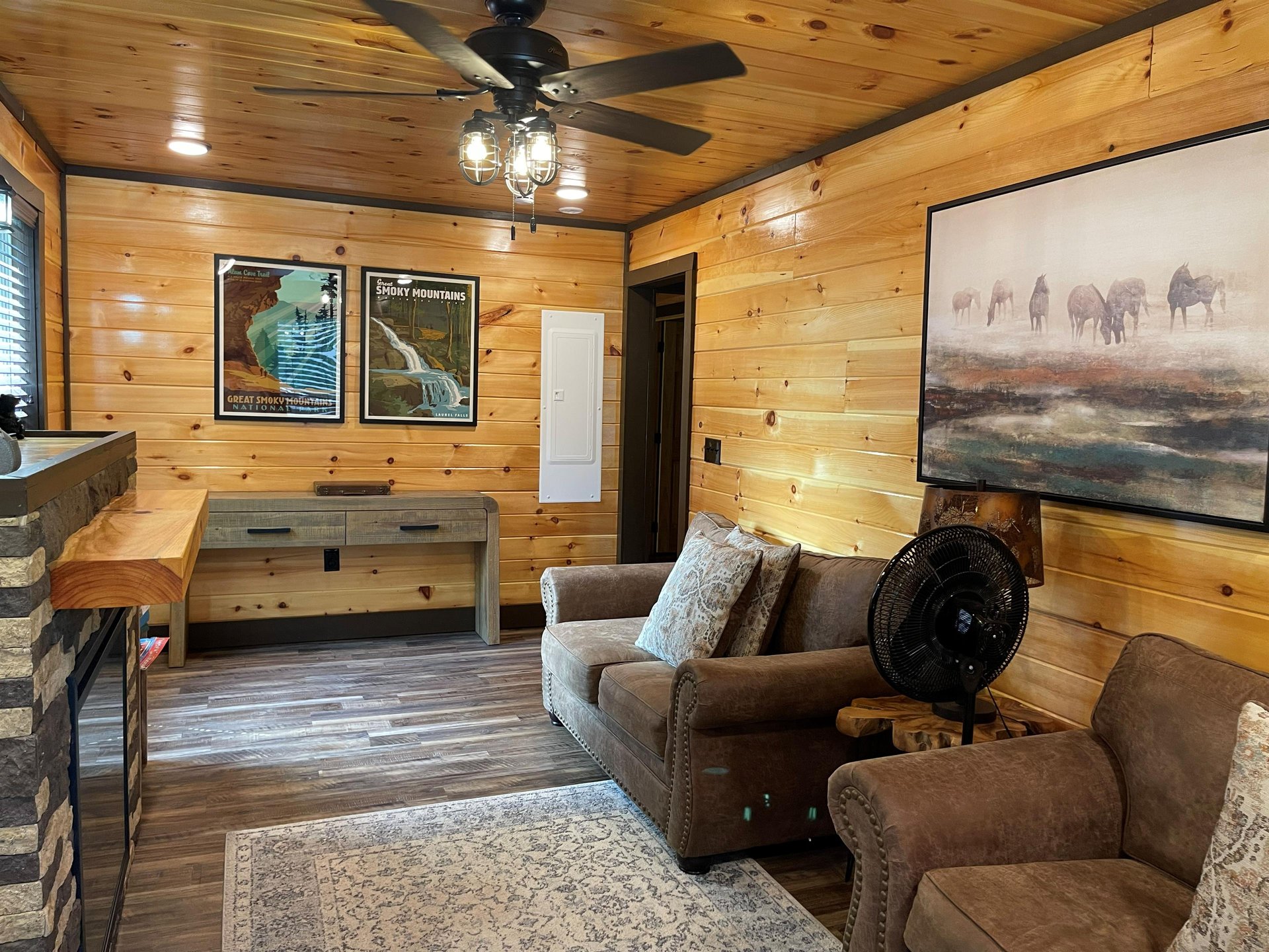 Sink into plush leather seating beneath rustic woodpaneled walls that wrap you in cabin warmth. The space invites you to unwind, whether youre enjoying the ceiling fans gentle breeze or simply soak