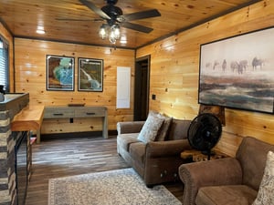 Sink into plush leather seating beneath rustic woodpaneled walls that wrap you in cabin warmth. The space invites you to unwind, whether youre enjoying the ceiling fans gentle breeze or simply soak