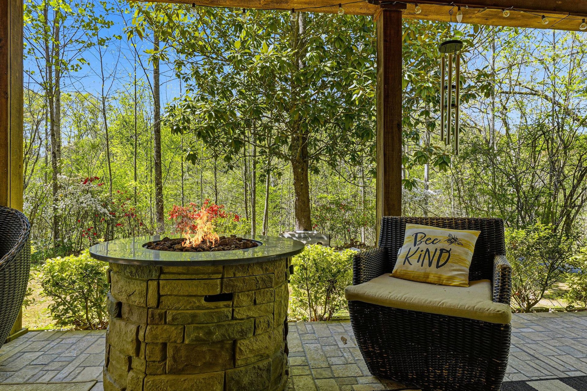 Unwind on your private covered patio with cozy seating around a crackling fire pit, surrounded by lush forest views.