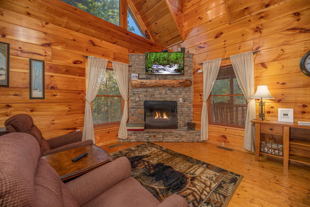 Living room with fireplace and TV at Firefly Ridge, a 2 bedroom cabin rental located in Pigeon Forge
