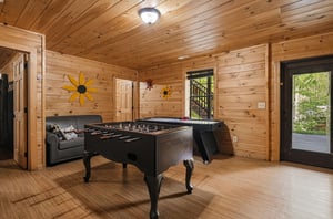 Challenge friends to foosball in your rustic game room, where warm wood walls and cheerful sunflower art create the perfect backdrop for funfilled evenings together.