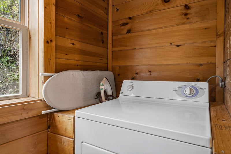 Your private laundry room features fullsize washer and dryer with builtin ironing board in warm wood surroundings.