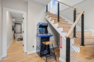 Challenge the high score on your own classic arcade machine—a fun surprise waiting just for you beneath the modern staircase.