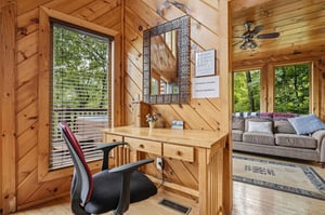 Your own workspace tucked into a cozy corner, framed by warm wood and natural light. Step outside to a private deck or unwind in the open living area nearby.