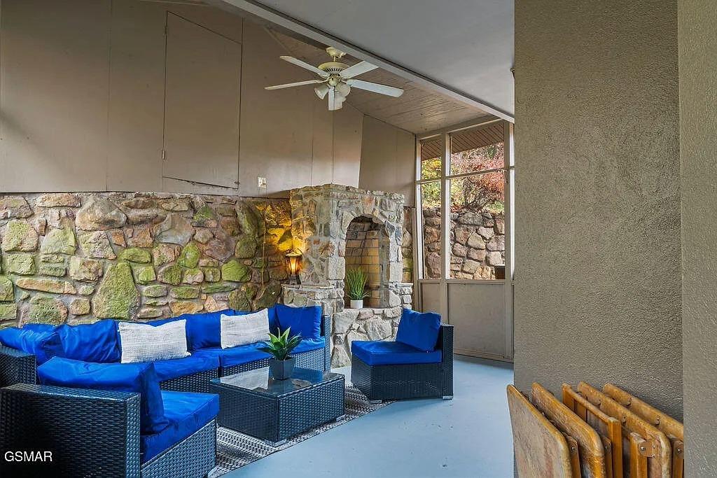 Relax in your private patio sanctuary, where vibrant blue seating meets stunning stone walls and cozy fireplace warmth.