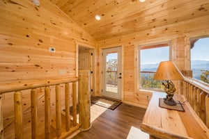 Upper level landing with balcony door and bedroom entrance on left