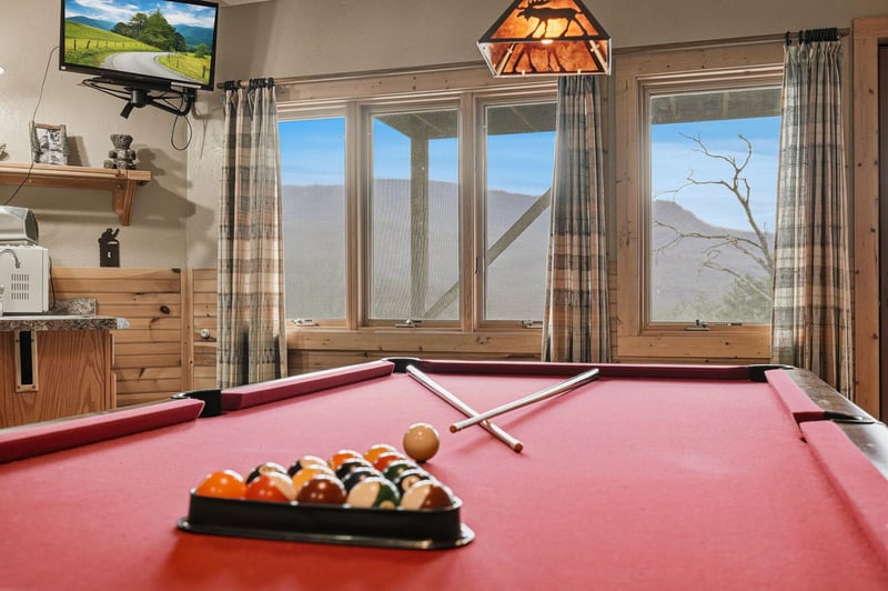 Challenge friends to pool while soaking in breathtaking mountain views through expansive windows in your cozy game room retreat.