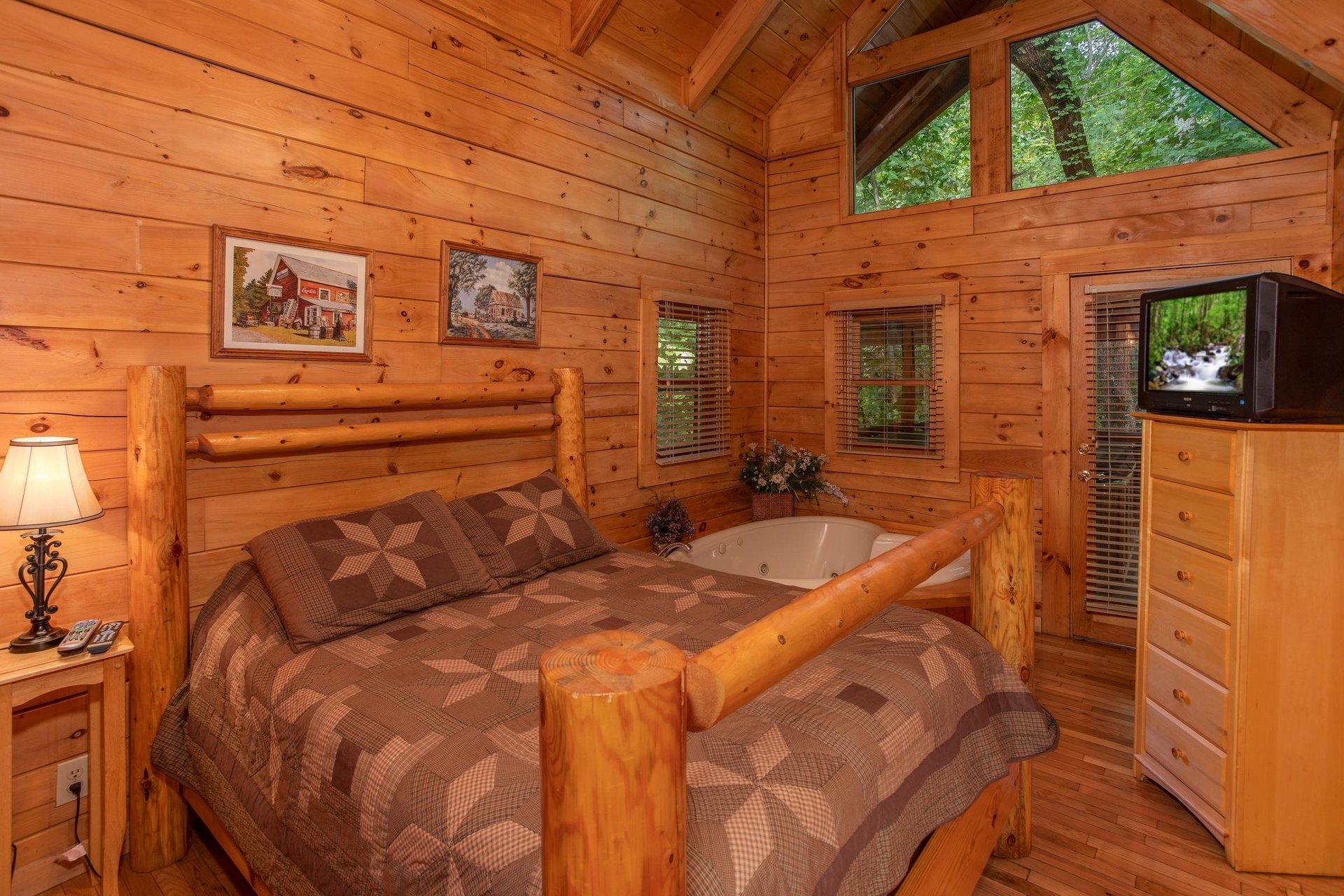 Bedroom with queensized log bed and a heartshaped jacuzzi at Dreams Do Come True, a 1bedroom cabin rental located in Pigeon Forge