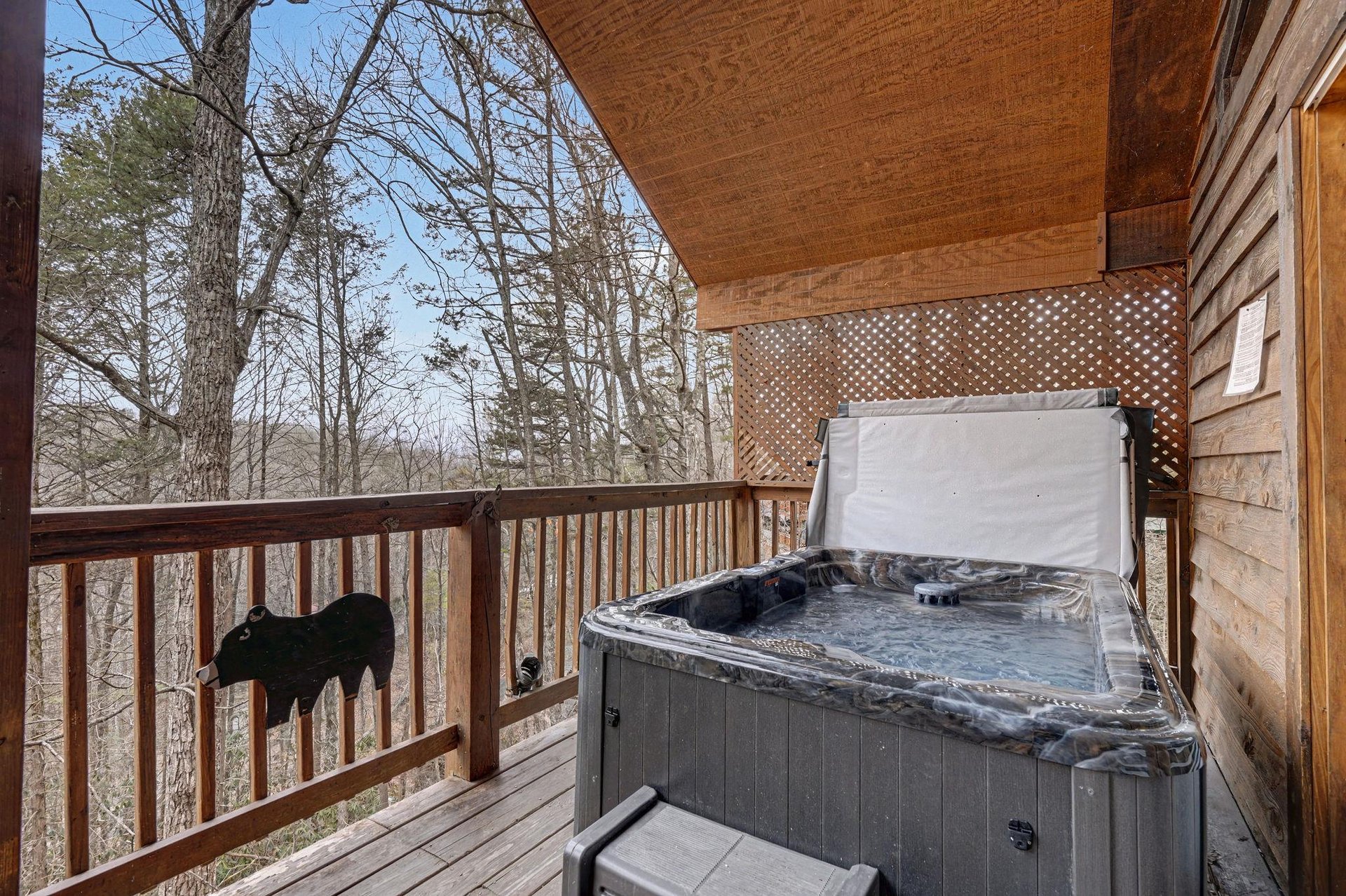 Soak in your private hot tub while surrounded by peaceful wooded views from this secluded deck.