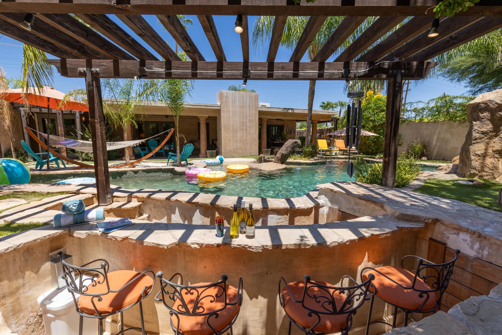 A gorgeous 4 bedroom, 4.5 bathroom home in Palm Springs, CA with 2 casitas, a lazy river, swim up bar, pickleball, basketball, putting green, games, and more