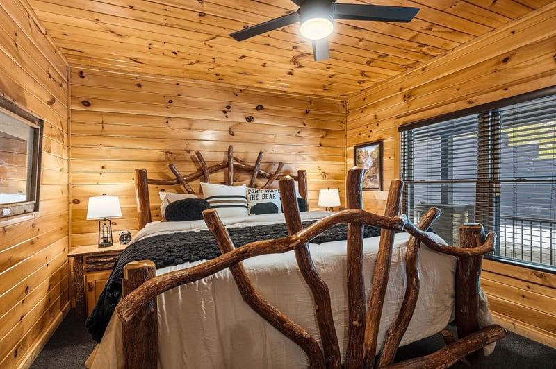 Drift off in this rustic retreat where natural wood wraps you in warmth and a handcrafted branch bed becomes your cozy cocoon beneath the soft glow of the ceiling fan.