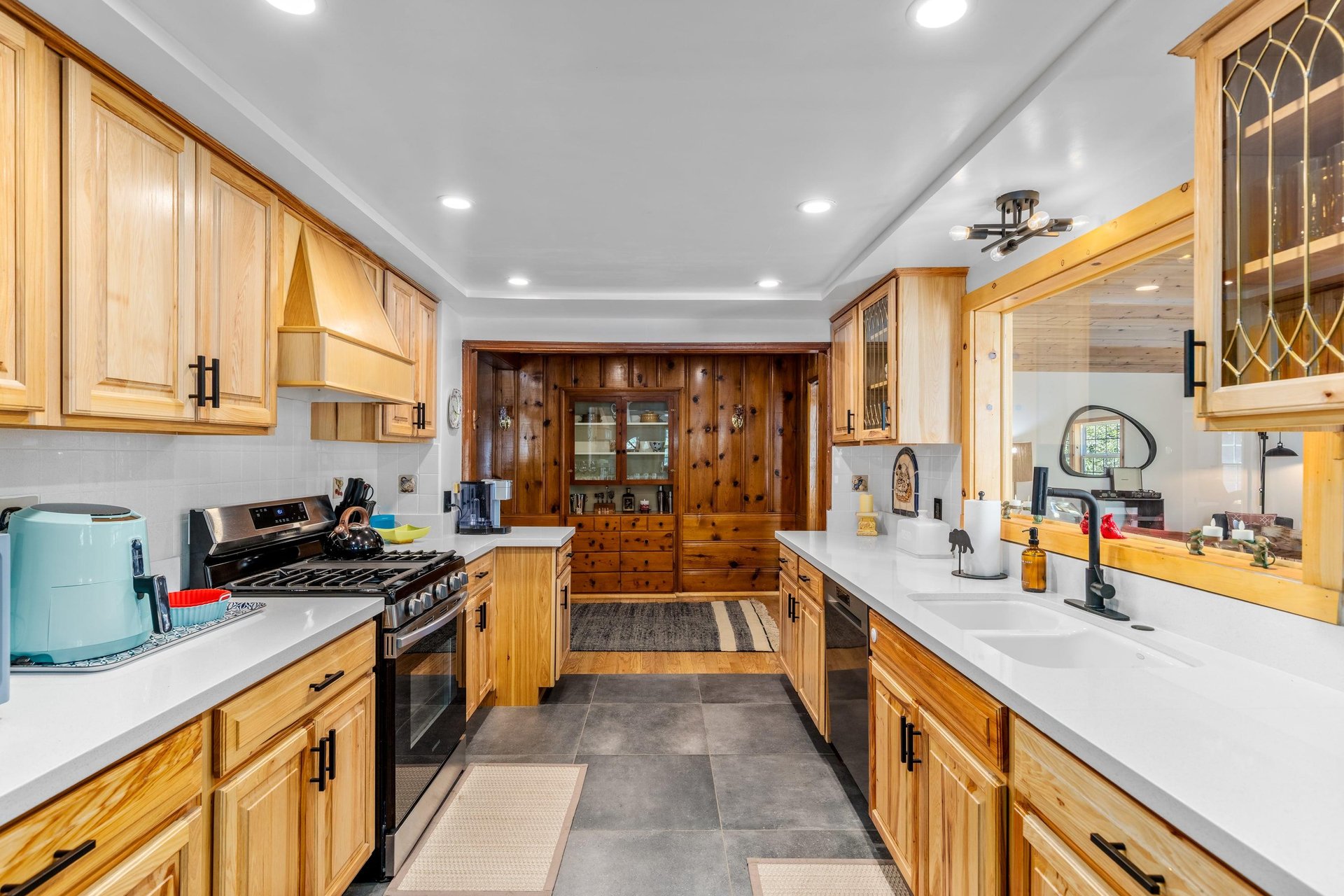 Stainless steel appliances, cooking essentials, and window into dining room.