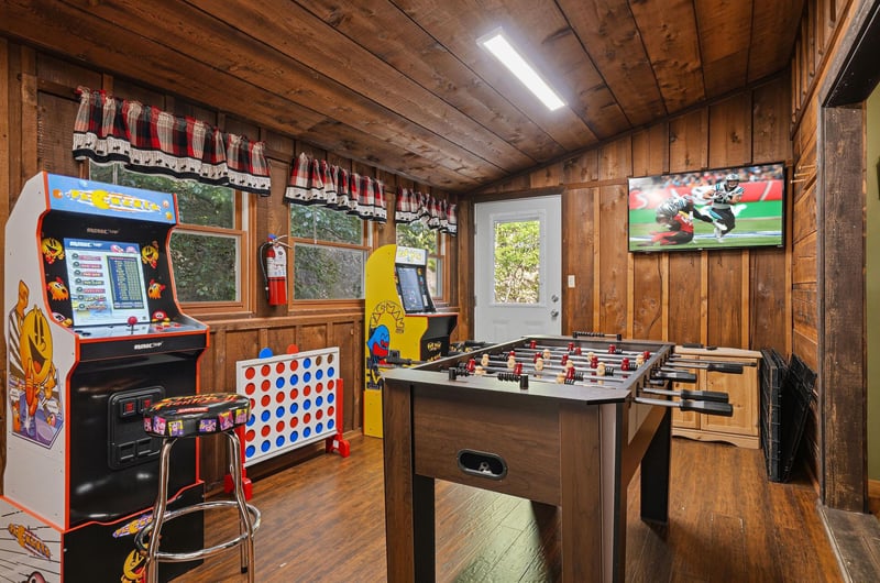 Your private game room awaits with arcade fun, foosball battles, and bigscreen entertainment in this cozy woodpaneled retreat.