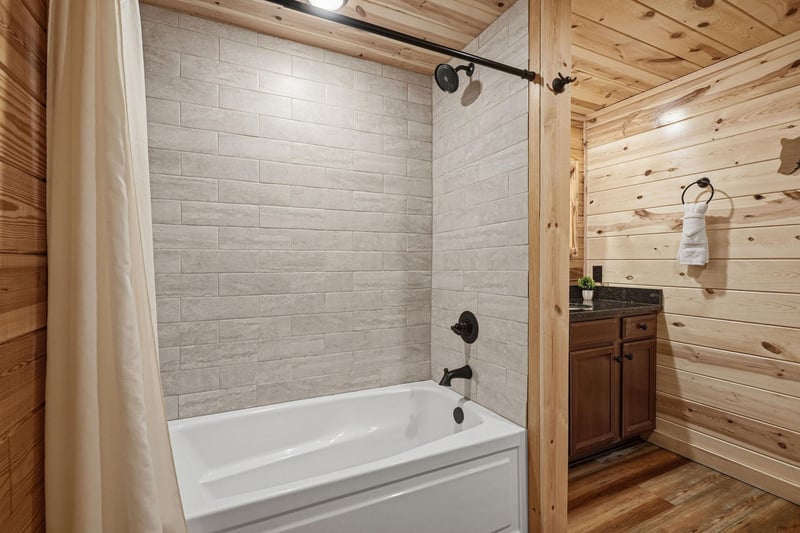 Your private bathroom awaits with a sleek tubshower combo, spalike tile, rustic wood accents, and fresh towels ready for your arrival.