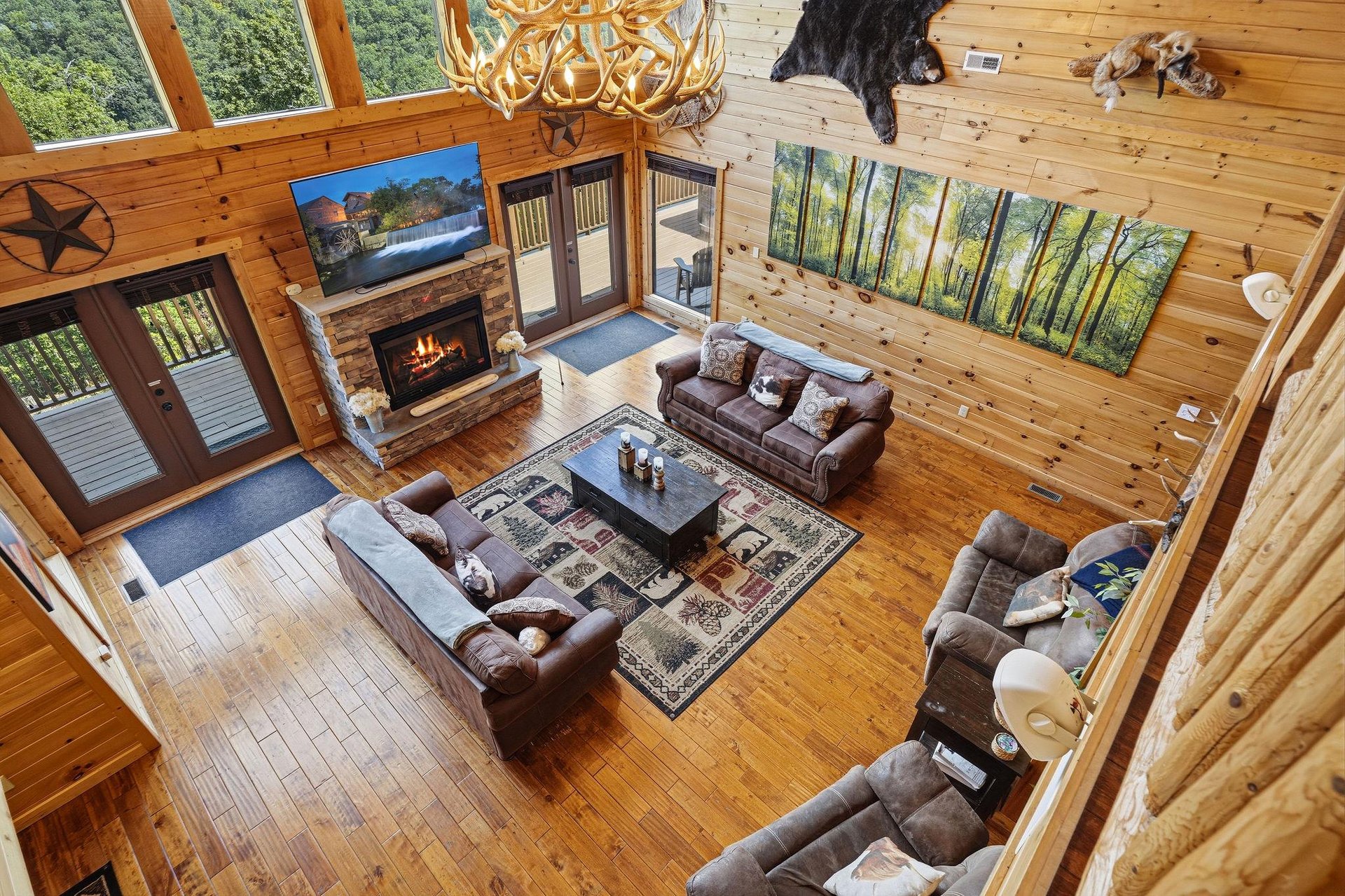 Imagine yourself relaxing in this stunning living room with soaring ceilings, cozy fireplace, and beautiful forest views through floortoceiling windows. Warm wood and rustic charm create the perfect