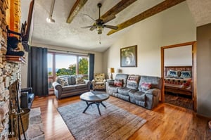 Unwind in your rustic living room with exposed beams, cozy fireplace, and comfortable seating perfect for relaxing after mountain adventures.