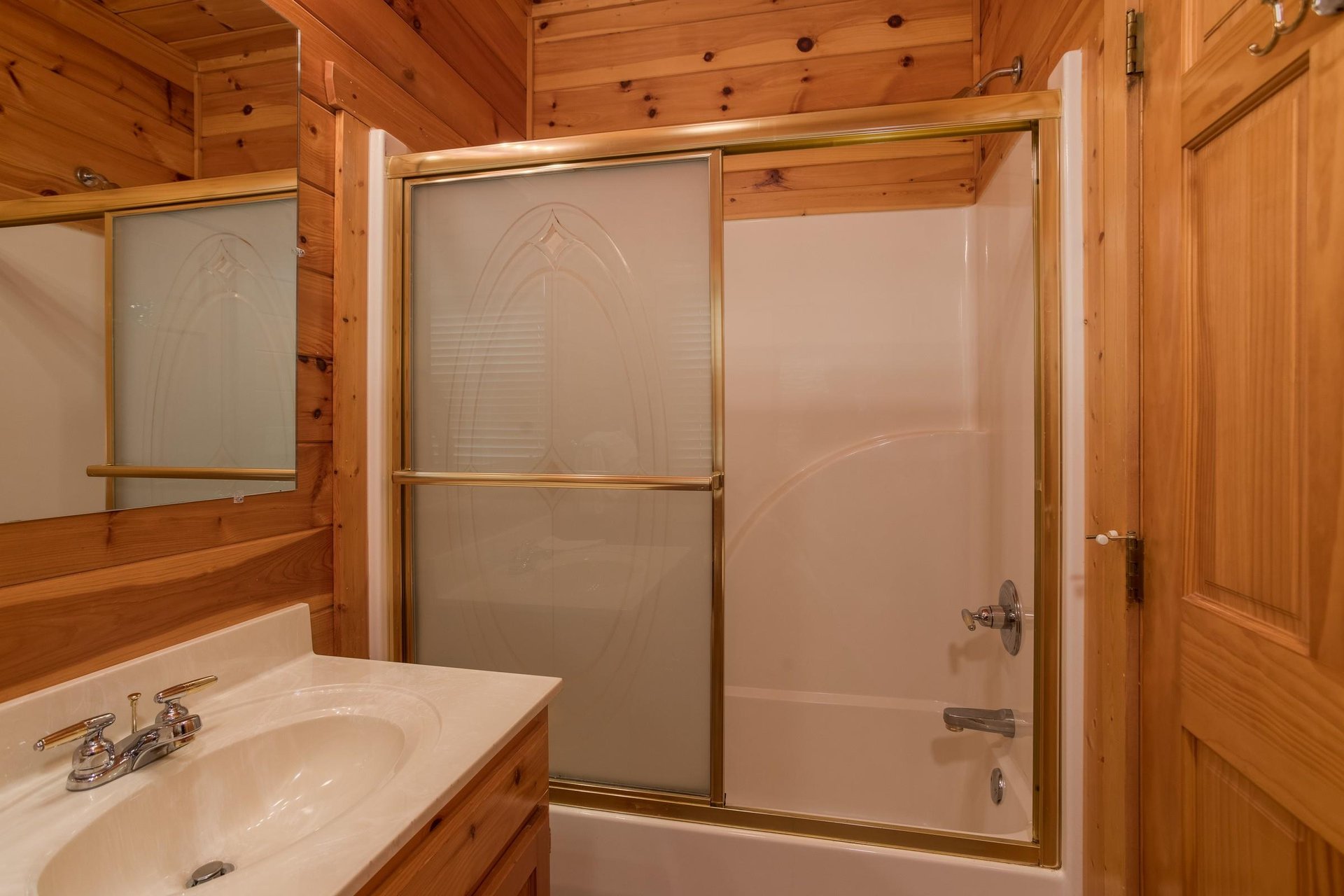Bathroom with a tub and shower at Howlin in the Smokies, a 2 bedroom cabin rental located in Pigeon Forge