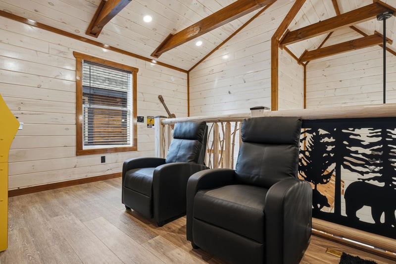 Sink into plush leather recliners beneath beautiful exposed beams. Your cozy loft retreat features rustic wood details that create the perfect ambiance for relaxing.