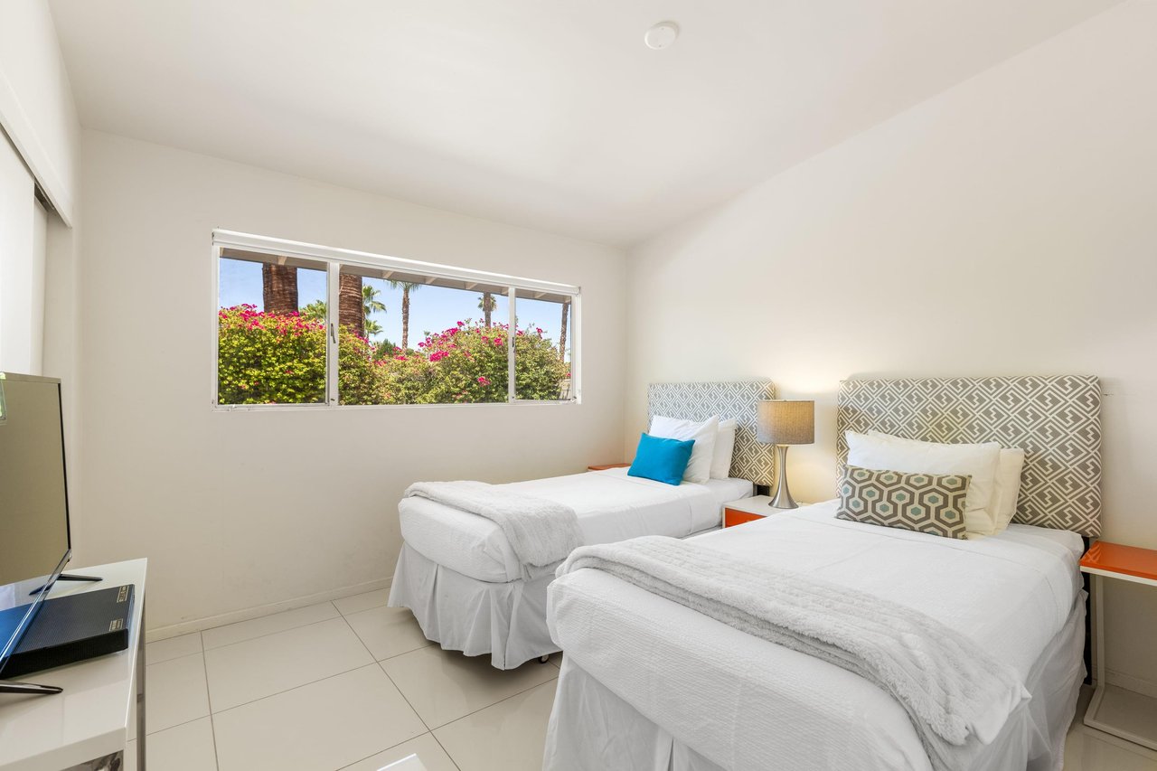 Two twin beds and a flatscreen TV.
