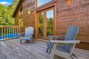 Step out onto your private deck and settle into an Adirondack chair, where warm wood tones and peaceful tree views create the perfect spot to unwind with morning coffee or evening conversation.