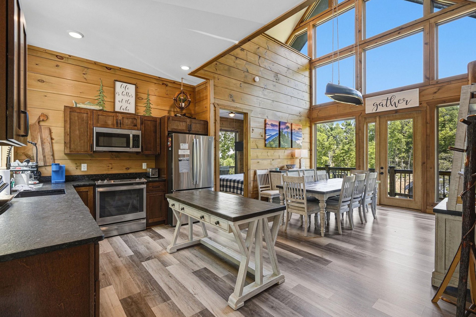 Gather around this stunning open kitchen with soaring windows that flood your space with natural light and forest views.