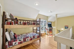 Your kids will love this spacious room featuring rustic bunk beds and a fun arcade game, perfect for creating lasting vacation memories together.