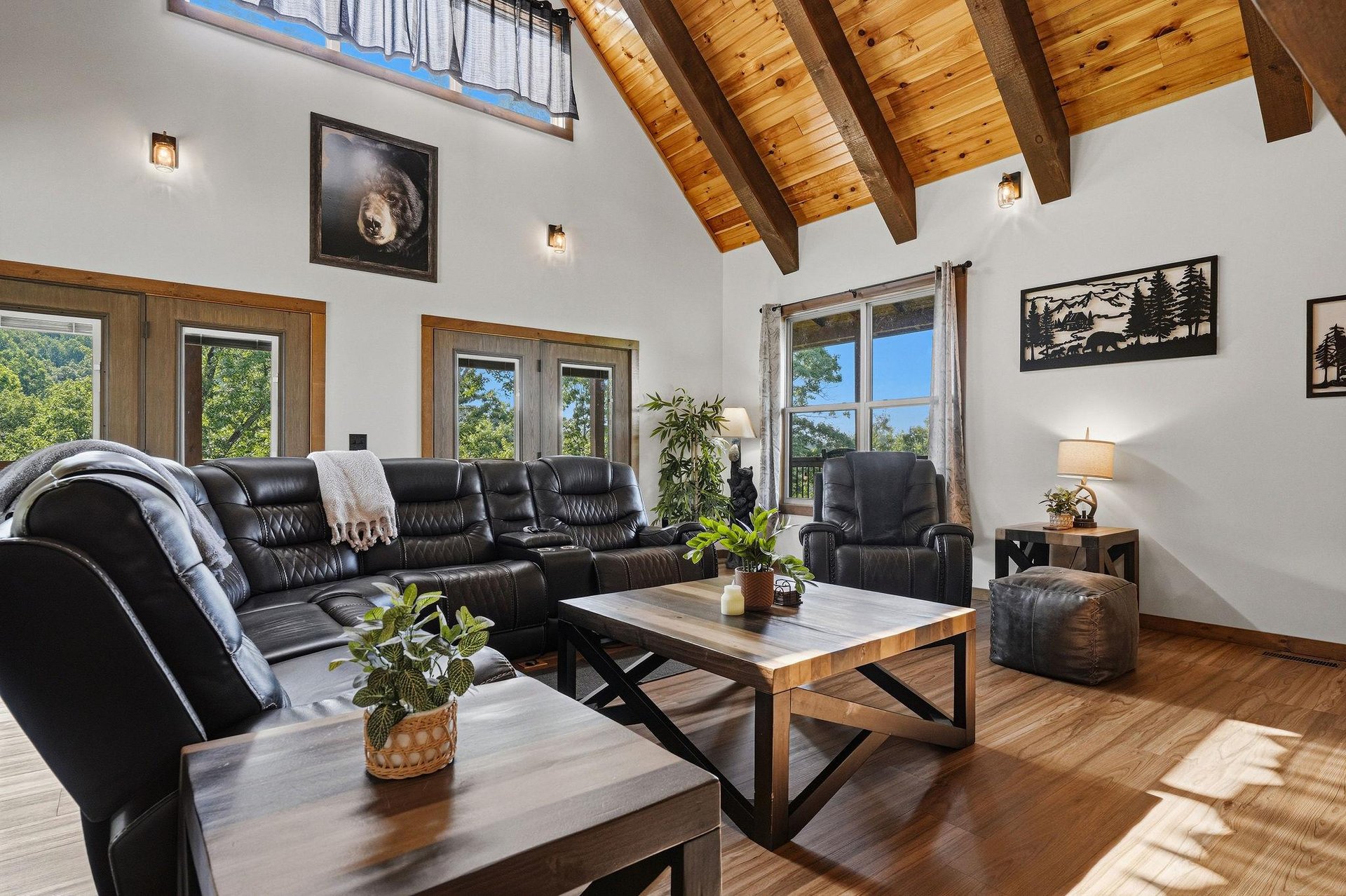 Sink into the leather sofa and soak in the soaring vaulted ceilings and bright natural light pouring through the windows, framing a peaceful wooded view.