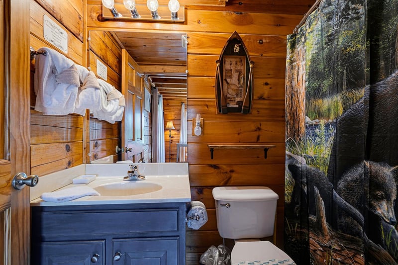 Step into your cozy bathroom with warm wood walls and thoughtful touches like soft towels and rustic decor—perfect for freshening up after a day outdoors.