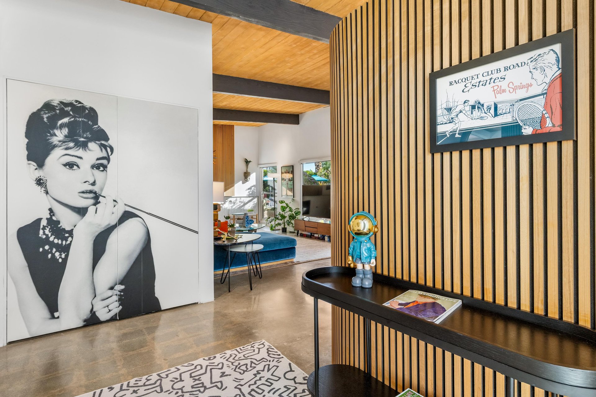 Step into this striking living space where iconic art meets modern luxury. Warm wood accents create an inviting atmosphere for relaxing.