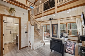 Cozy up in your rustic retreat with soaring ceilings, natural wood beams, and a bright loft overlooking your peaceful living space.