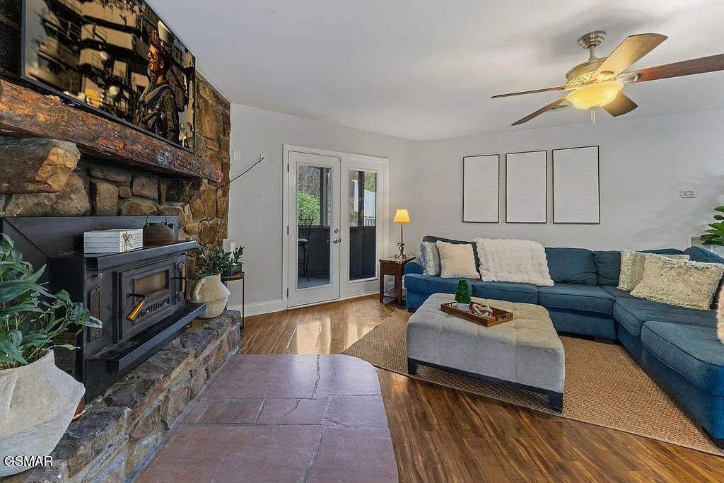 Sink into the plush sectional by your cozy stone fireplace, where warm evenings and peaceful moments await in this inviting living space.