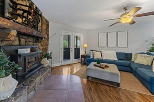 Sink into the plush sectional by your cozy stone fireplace, where warm evenings and peaceful moments await in this inviting living space.