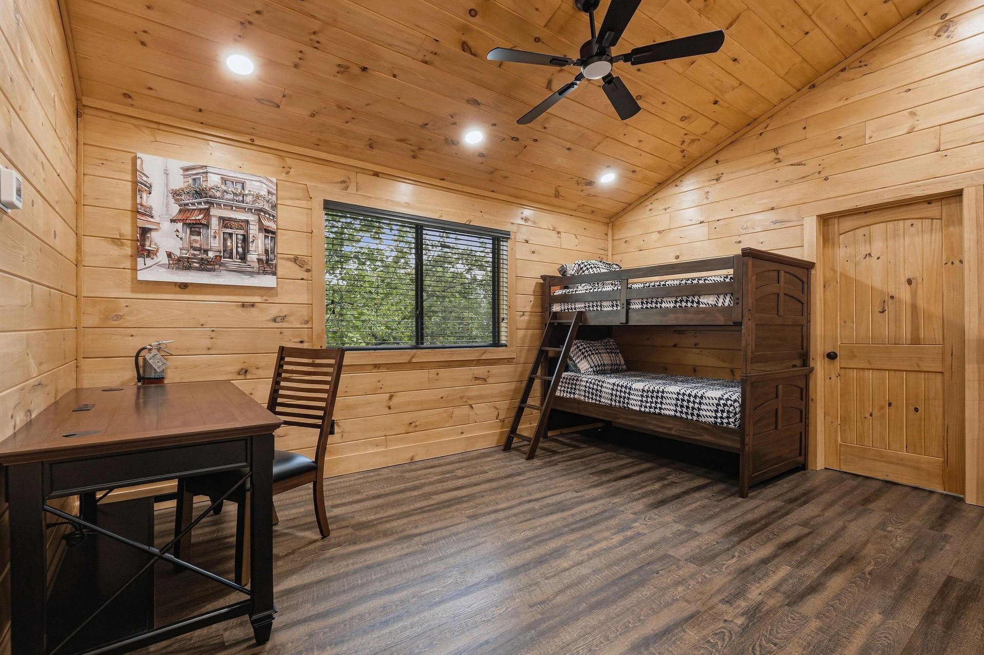 Your cozy cabin bedroom features rustic bunk beds and a workspace desk, perfect for family adventures in the woods.