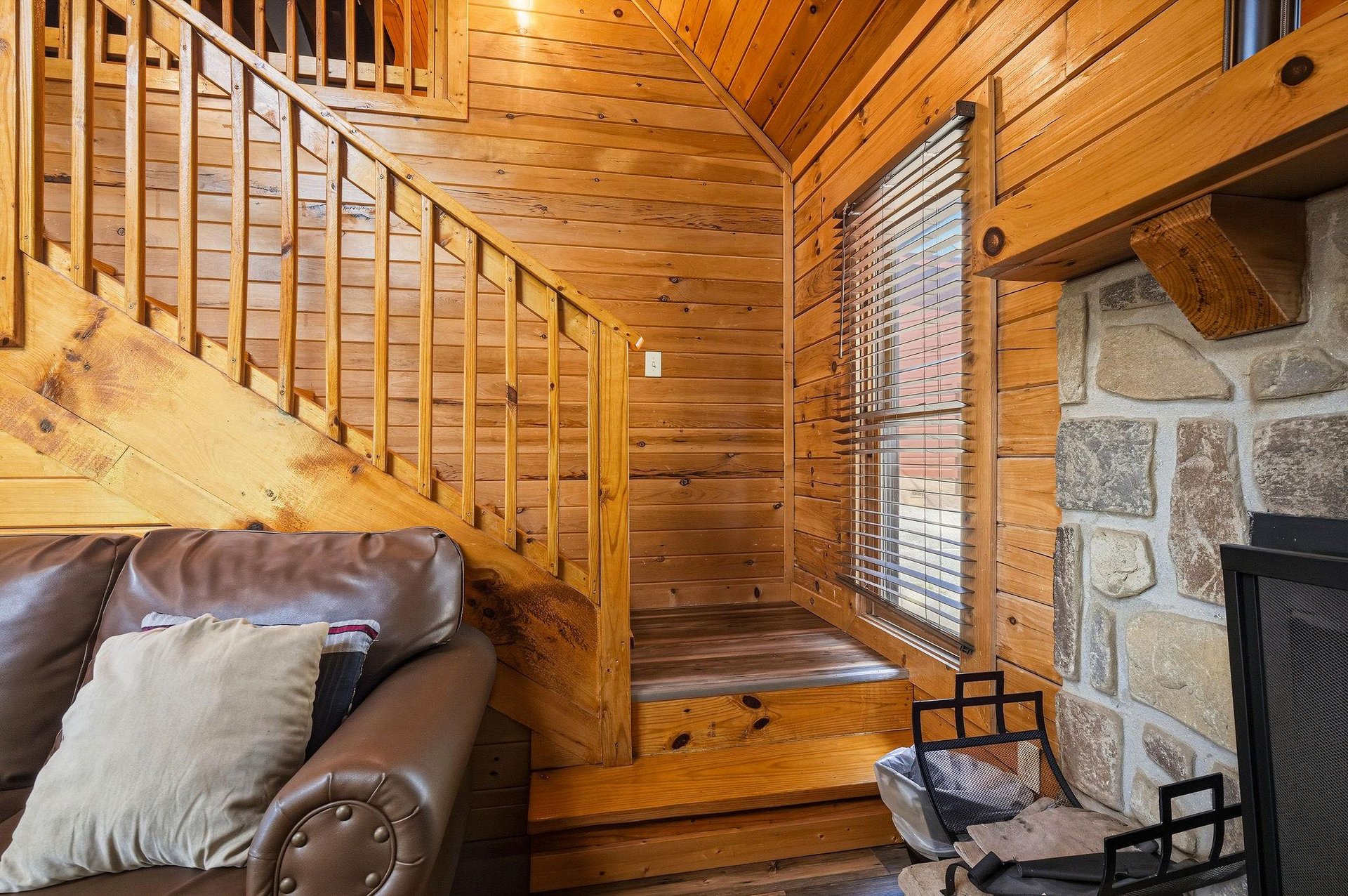 Sink into the cozy leather sofa and feel the warmth of your stone fireplace as natural light filters through the windows of your charming cabin retreat with a lofted second level.