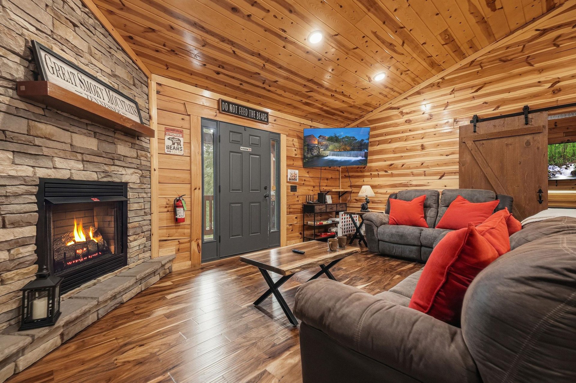 Curl up by the glowing fireplace in this warm, inviting cabin living space with soaring woodbeamed ceilings and plush seating perfect for relaxing after your mountain adventures.