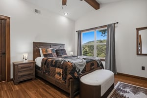 Wake up in this cozy bedroom with warm wood accents and vaulted ceilings. Your mountain view framed by the window invites peaceful mornings and serene evenings.