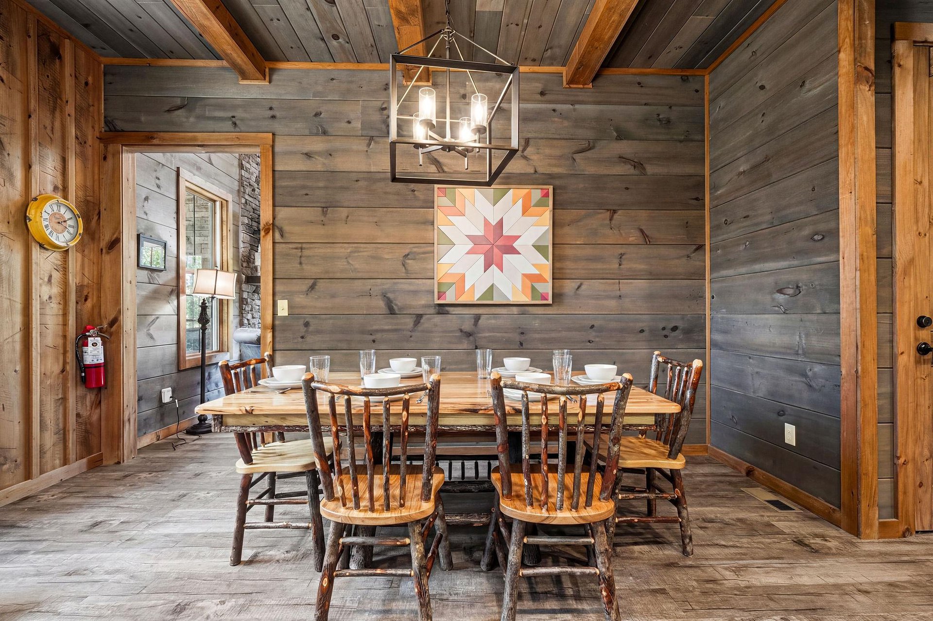 Gather with loved ones around the farmhouse table in this cozy dining space, where rustic wood walls, vaulted beamed ceilings, and a handcrafted lantern create a warm, inviting atmosphere for memorabl