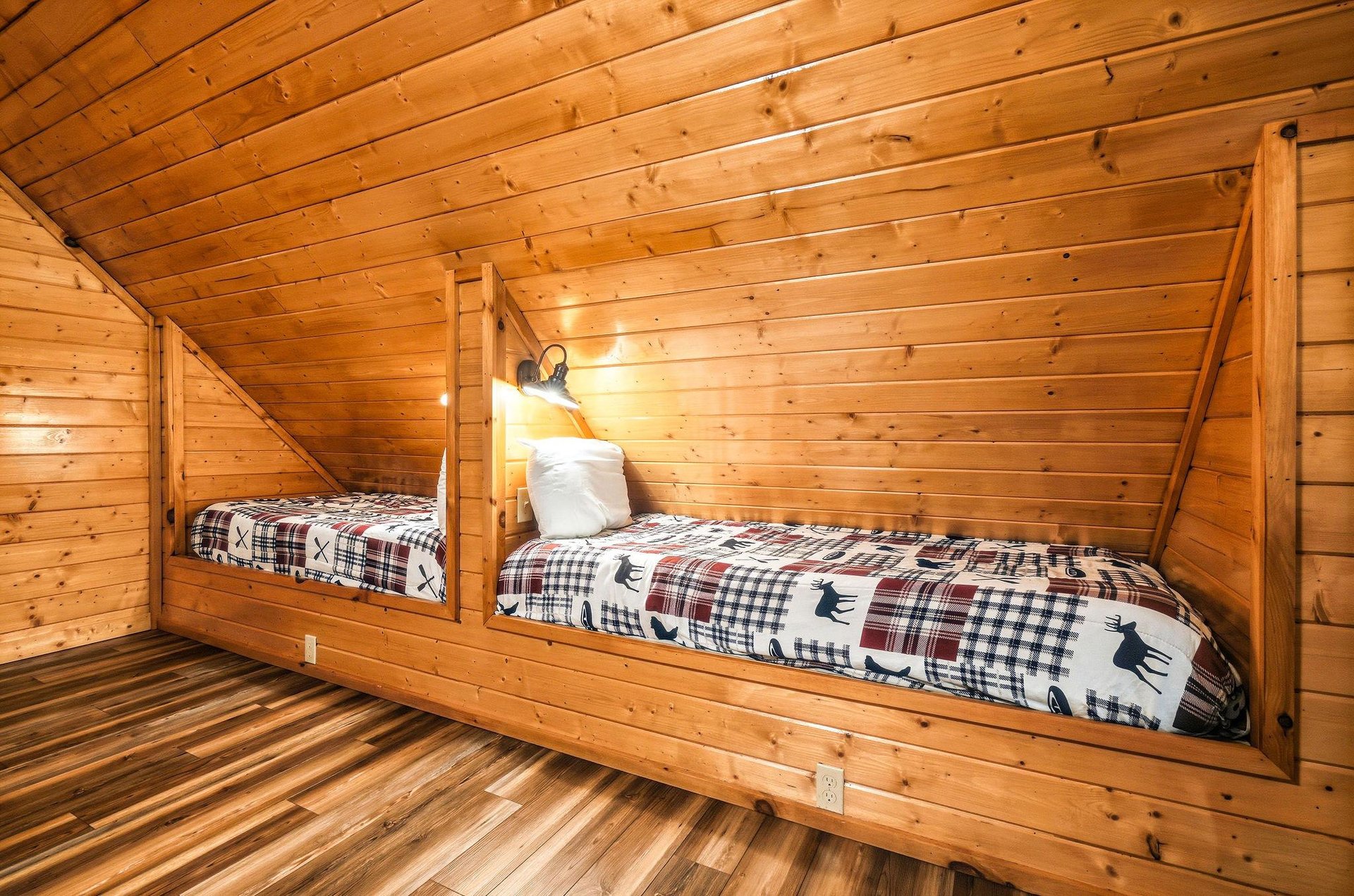 Cozy builtin bunk beds with rustic plaid bedding invite restful nights beneath warm woodpaneled ceilings and soft cabin lighting.