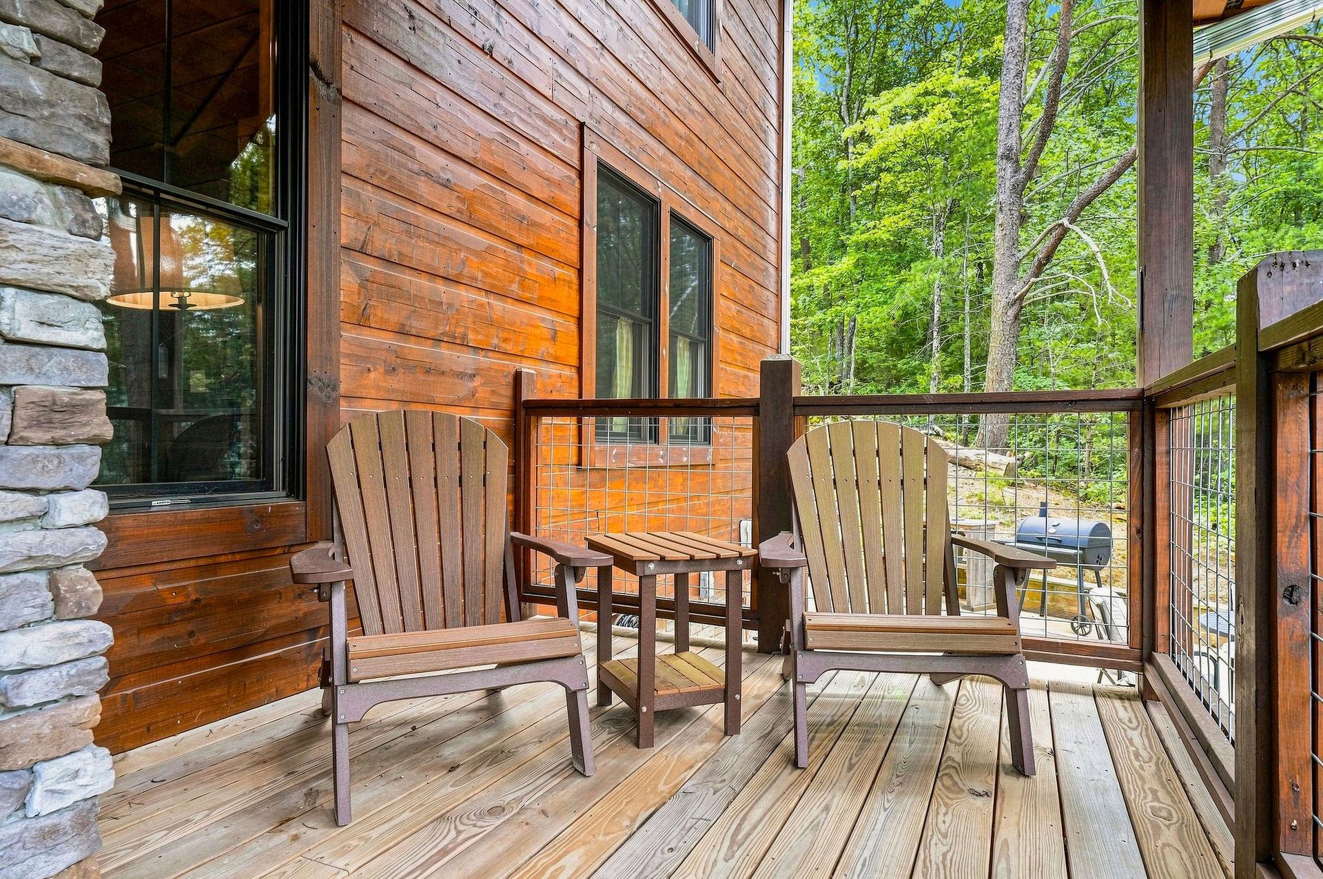 Picture yourself relaxing in your own private balcony, surrounded by lush forest views. Two Adirondack chairs invite you to unwind with your morning coffee while birdsong fills the air.