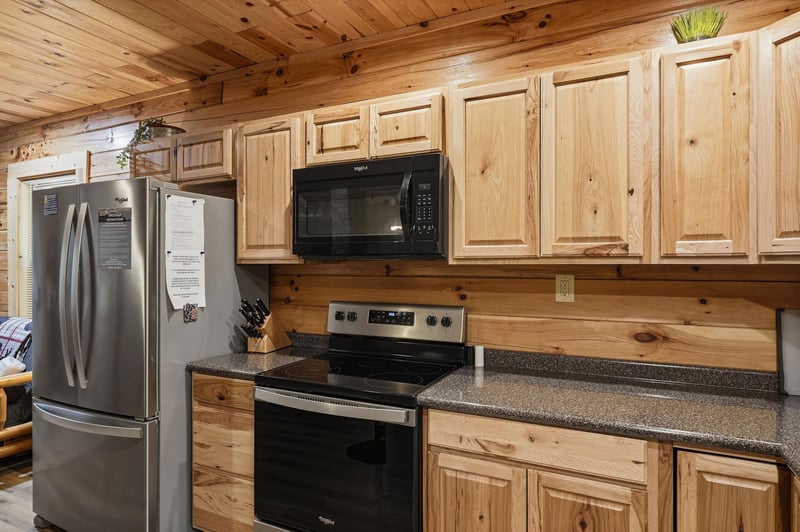 Your fully equipped kitchen features modern stainlesssteel appliances, granite countertops, and warm knotty pine cabinetry throughout—perfect for preparing family meals in a cozy mountain retreat set