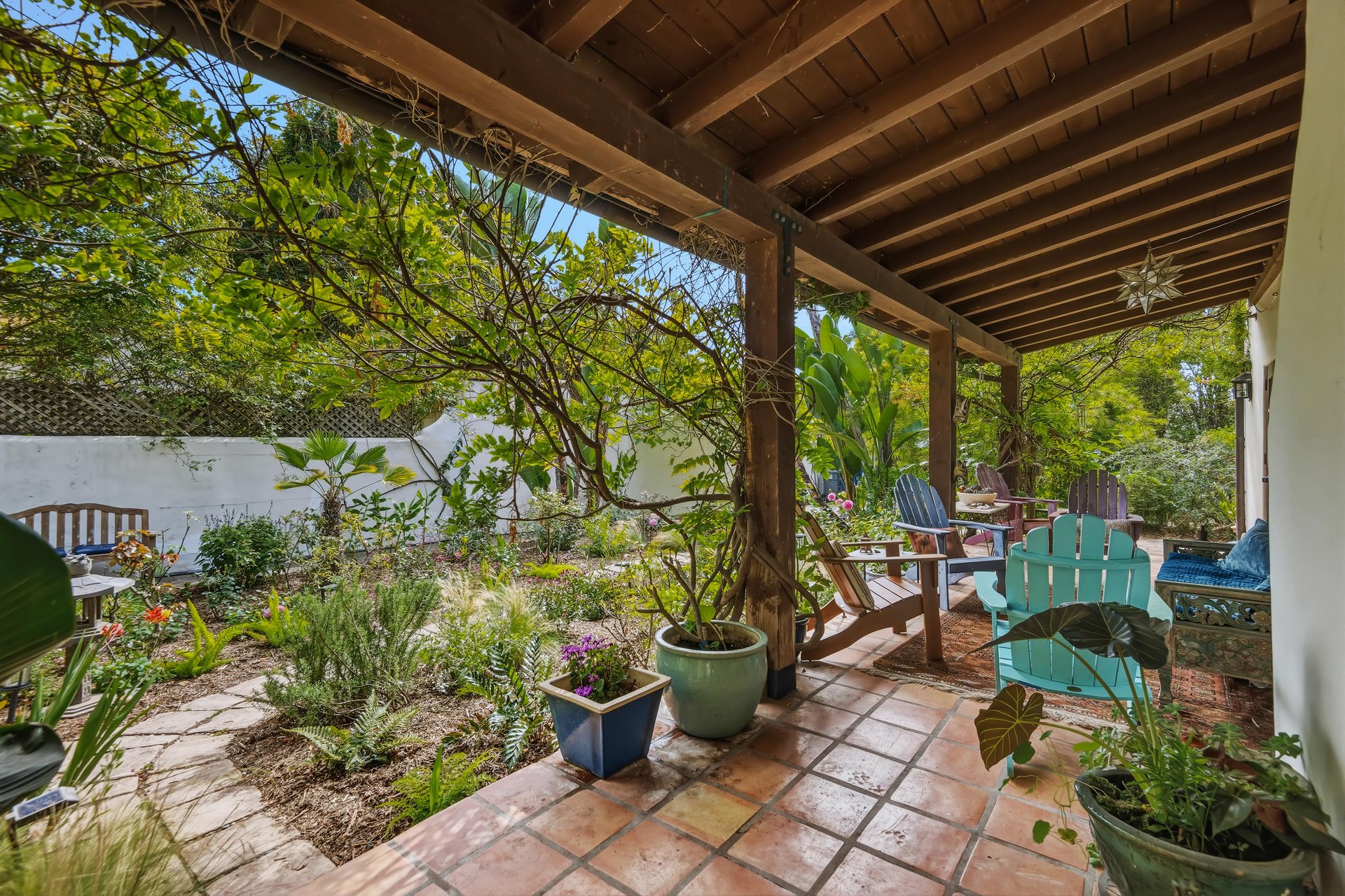 Stunning patio with mosaic tiles, outdoor seating, and an outdoor shower.
